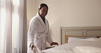 Sheets, black woman and making bed in hotel room for morning routine, maintenance and getting ready. Tourist, hospitality and cleaning in bedroom of resort for travel, vacation and holiday with robe