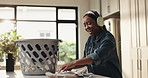 Woman, happy and laundry basket with headphones in home for cleaning routine, hygiene and singing. African person, folding clothes and linen with audio streaming with dance for housework at apartment
