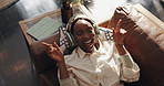 Headphones, relax and above of black woman on sofa for streaming subscription, track and playlist. Home, happy and person on couch for listening to music, radio and audio in living room on weekend