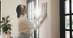 African woman, painting and frame at house for decoration, interior design and aesthetic lounge. Female person, hang and picture on wall to display memory, artistic upgrade and remodeling process
