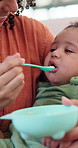 Mother, spoon and feeding baby in home with play, airplane or smile for nutrition with development. Woman, mom and infant child with game, food or healthy diet for growth with bonding at family house