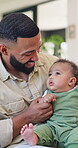 Father, dancing and playing with baby on home sofa for bonding, love and care of proud parent. Happy man, healthy son and together in family house with protection, smile and childcare in living room