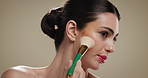 Woman, makeup brush and foundation for beauty, application and face on studio background. Creative, person and model with tools, process and aesthetic for cosmetics for wellness and transformation