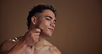 Beauty, massage and man with gua sha, facial treatment and skincare with tool and studio background. Cosmetic, grooming and wellness for person with product, healthy skin or self care for smooth face