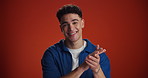 Face, happy man or clapping for success in studio for goal achievement, winning or congratulations. Smile, portrait or applause on red background with prize space for support, encouragement or award