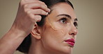 Skincare, face and serum application for beauty, dermatology or glow. Cosmetic product, pipette or model apply hyaluronic acid, vitamin c or collagen treatment with essential oil on studio background