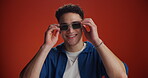 Smile, man and sunglasses for fashion in studio background with vibe, trendy clothes and retro style. Portrait, male person and pride of streetwear outfit, accessories and good mood for bold attitude