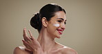 Woman, skincare and cosmetics with face cream for moisturizer on a studio background. Female person, model and smile with lotion or makeup for skin glow, shine or anti aging facial treatment on space