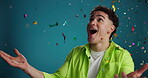 Surprise, excited and man with confetti celebration on studio background for winner, reward or deal. Announcement, contestant and happy with giveaway prize for game show success, competition or bonus