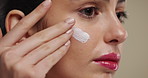 Woman, skincare and lotion with face cream for anti aging beauty  treatment on a studio background. Female person, model and smile with moisturizer product for skin glow, shine or facial cosmetics