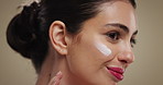 Woman, skincare and cosmetics with face cream for anti aging treatment on a studio background. Female person, model and smile with lotion or moisturizer for skin glow, shine or facial treatment