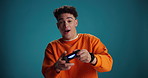 Video games, excited and face of man in studio for online competition, challenge and esports. Space, gamer and portrait of person with console remote for fun, playing and happy on blue background