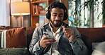 Dance, headphones and phone with man on sofa for streaming, music playlist or relax. Audio subscription, calm podcast and connection with person in living room of home for album, sound and listening