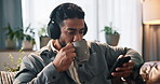 Coffee, music and phone with man on sofa for streaming, songs playlist or relax. Audio subscription, calm podcast and connection with person in living room of home for album, headphones and listening