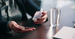 Pills, water and hands of person in home with medicine, prescription and medication. for recovery Health, tablets and patient with container for vitamins, supplements and drugs for medical symptoms