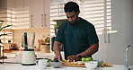 Smoothie, kitchen and man cutting banana in home for nutrition breakfast, snack or diet. Blender, weight loss and male person with organic fruit for health, wellness or morning drink in house.