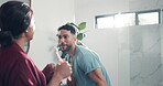 Playful, couple and dancing in bathroom, fun or happiness for hygiene in home, relationship or love. Karaoke, man and woman with toothbrush, grooming and performance in house, singing or romance