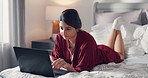 Woman, research or relax with laptop on bed for online browsing, social media or connection in home. Female person, user or typing with computer for network, web search or software update in bedroom
