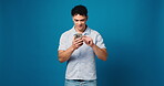 Scroll, phone and reading with man in studio for social media, text message and communication. Connection, browsing online and chat with person and mobile on blue background space for network and app