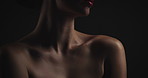 Glow, skincare and cosmetic with woman in studio on dark background for shadow, art or cosmetology. Beauty, dermatology and lighting for serious model in shade for change, transformation or aesthetic