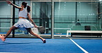 Action, woman and playing padel on court for match competition, game training or serving ball. Fitness, player or ready with racket at indoor club for technique practice, sports performance or energy