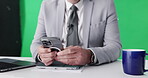Hands, person and scroll with phone in studio for reading notes, breaking news and reporting script. Mockup space, man and mobile for research, media information and newsroom feedback on green screen