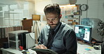 Detective, tablet and reading with man in office for police records, evidence report and night. Crime investigation, criminal database and case files with person in precinct for murder clues deadline
