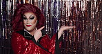 Face, offer and pointing with drag queen in night club for identity, performance or self expression. Makeup, palm and showing with lgbt person in theater for announcement, cosmetics or individuality