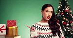 Face, woman and pointing on Christmas in studio, show direction and giveaway announcement. Portrait, female person and information for holiday celebration, festive news and sales on green background