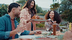 Friends, food and turkey for lunch outdoor with conversation, bonding and social gathering. Thanksgiving celebration, people and happy with meal for holiday, reunion and weekend break or event