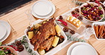 Table, food and holiday with dinner party in house, roast meal with chicken and vegetable for Christmas. Gourmet cuisine, place setting or arrangement for supper feast with Thanksgiving event at home