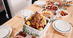 Table setting, food and holiday with dinner party in house, roast meal with chicken and vegetable for Christmas. Gourmet cuisine, nutrition with feast or supper with Thanksgiving event at home