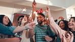Christmas, sparklers and people in home for party, celebration or event in festive season together. Happy, fireworks and group of excited friends dancing for xmas holiday with reunion in apartment.