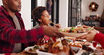 Christmas, father and eating dinner with kid in home for love, talk or bonding together. Xmas, parent and share meal with child for holiday celebration, festive food or pass plate with African family