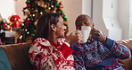 Christmas, coffee and African couple with toast, tree and love in living room of house together. Talk, smile and man with woman, xmas and holiday or vacation bonding for festive season or tradition