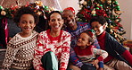 Face, family and celebration of Christmas, laughing or home on festive season, bonding and December. Happy, man and woman with children on Xmas holiday, African and embrace with kids, lounge or house