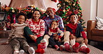 Face, family and celebration of Christmas, bonding or home on festive season, laughing and December. Happy, man and woman with children on Xmas holiday, African and embrace with kids, lounge or house