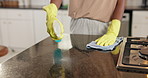 Person, hands and cleaning with spray in kitchen for hygiene or disinfection in home. Closeup, cleaner or maid wiping surface with gloves, cloth or detergent for dust, germ or dirt removal in house