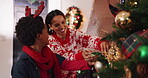 Mother, son and tree with decoration for Christmas, festive celebration or holiday tradition. Smile, woman and child with ornaments, help and flare for family bonding and prepare xmas season in home
