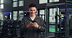 Smile, man and typing with phone at gym for social media, fitness app and sign up on website. Happy, male person and mobile for research, review progress and online notification of sports membership