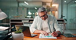Finance, documents and businessman on laptop writing for budget planning, investment research and profit. Mature, paperwork and person on computer with statistics, graph and info for financial report