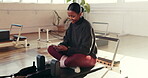Phone, pilates and smile of woman on studio floor for break from exercise or fitness routine. App, social media and text message with happy person in health class for communication or recovery