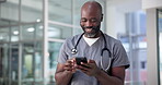 Doctor, man and happy with phone in clinic for healthcare results, medical update and telehealth. Medicine, mature black person or smile with smartphone in hospital for communication or health report
