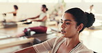 Woman, pilates and coach with talk, reformer machine and instructor for exercise at fitness club. Person, trainer and guide with training, workout or wellness with group, class and rowing at studio