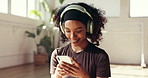 Woman, headphones and phone in yoga class for social media, podcast or typing on fitness app. Smile, female person or yogi on smartphone for online chatting, texting and music break for pilates