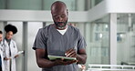 Medical, tablet and walking with black man nurse in hospital for insurance, telehealth or update. App, healthcare and scrubs with medicine professional in clinic for agenda, planning or research