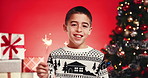Christmas tree, face and sparkler with boy on red background for celebration of holiday season. Festive, fireworks and smile of happy child in studio for excitement of December gifts or presents