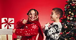 Christmas, dance and children in studio excited for holiday, festive season and celebration with tree. Family, siblings and boy with girl with energy for xmas, party and event on red background