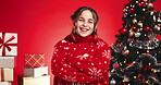 Arms crossed, Christmas tree, face of girl on red background for festive excitement or tradition. Celebration, event and season with happy child in studio for gifts or presents in December holidays