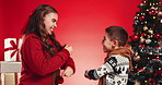 Christmas, dance and kids in studio excited for holiday, festive season and celebration with tree. Family, siblings and boy with girl with energy for xmas tradition, party and event on red background